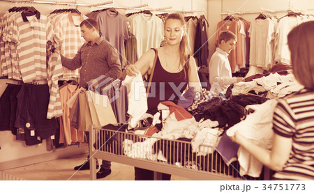 People of different ages looking clothes a half-off sale 34751773