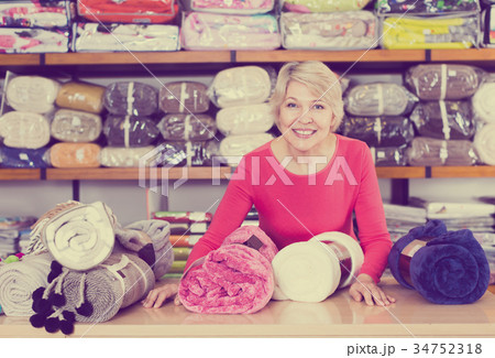 Cheerful shop assistant demonstrating assortment Cheerful shop assistant demonstrating assortment 34752318