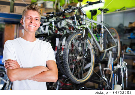 Portrait of male standing near the bicycle in the shop 34752502