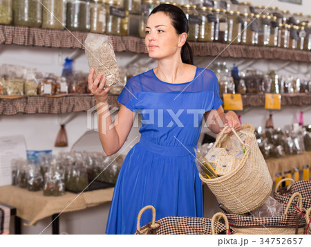 adult female choosing natural dried herbs sold by weight in eco shop adult female choosing natural dried herbs sold by weight in eco shop 34752657