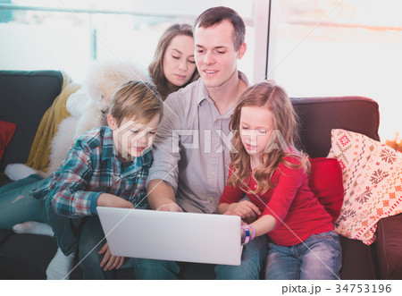 Young cheerful family watching movie on laptop together at home Young cheerful family watching movie on laptop together at home 34753196