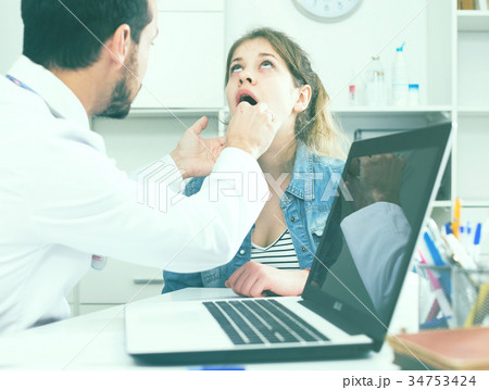Doctor and girl with sore throat Doctor and girl with sore throat 34753424