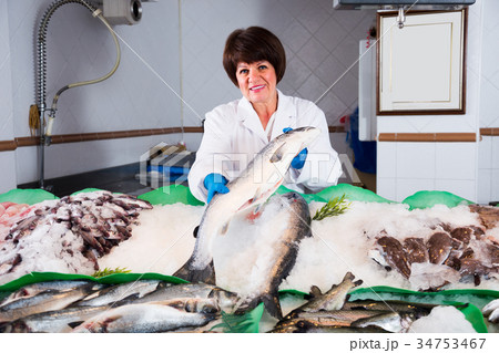 Female seller offering fresh fish Female seller offering fresh fish 34753467