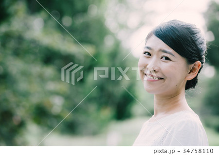 笑顔の30代日本人女性 新緑の公園 笑顔の30代日本人女性 新緑の公園 34758110