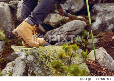 hiking boots close-up. girl tourist steps on the hiking boots close-up. girl tourist steps on the 34760164