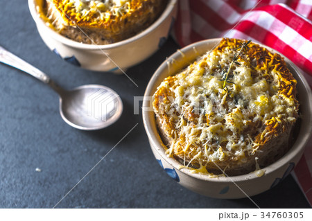 Ceramic bowls with onion soup, spoon and napkin 34760305