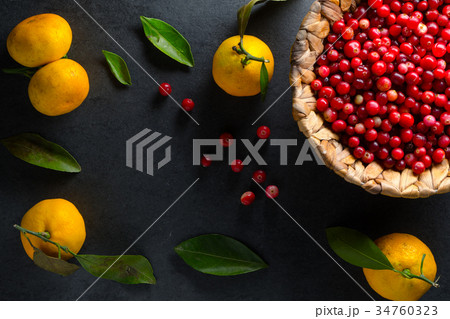 Yellow mandarins with leaves and cranberries in a 34760323