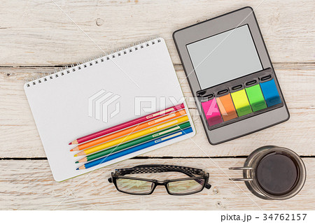 Top view: ebook, notebook and colored pencils Top view: ebook, notebook and colored pencils 34762157