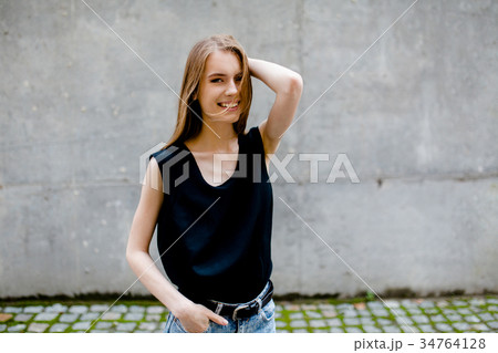 Attractive smiling young woman standing in the 34764128