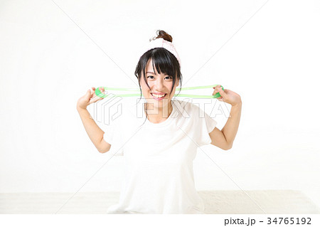 若い女性　部屋でエクササイズ　トレーニングチューブを使って 34765192