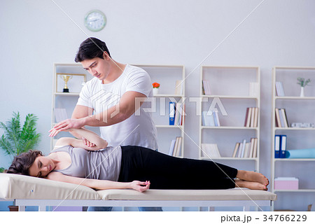 Young doctor chiropractor massaging female patient 34766229