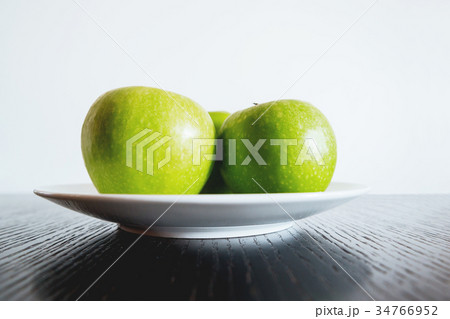 Three fresh green apples on white plate. 34766952