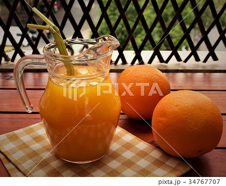 Orange juice in a jug on the veranda table. 34767707