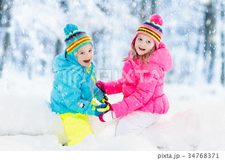 Kids playing in snow. Children in winter snowfall Kids playing in snow. Children in winter snowfall 34768371