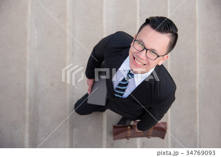 businessman wearing black suit smiling on stair 34769093