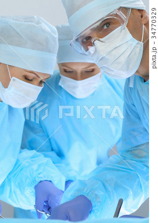 Medical team performing operation. Three of Medical team performing operation. Three of 34770329