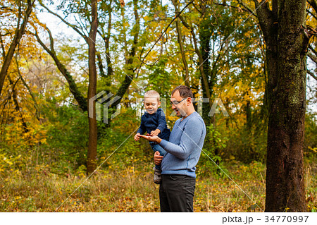 Dad and son in the autumn park 34770997