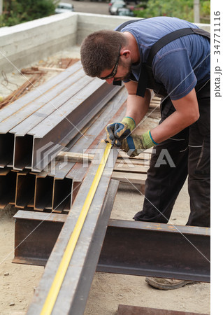 A man marks a metal product before cutting A man marks a metal product before cutting 34771116