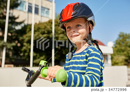 Boy in helmet standing with bike at autumn park 34772996