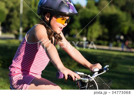 Portrait of a little girl in helmet on a bicycle Portrait of a little girl in helmet on a bicycle 34773068