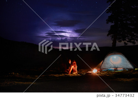 Night camping in the mountains. Couple tourists Night camping in the mountains. Couple tourists 34773432