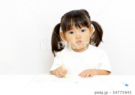 クレヨンで絵を描いて遊ぶ幼い女の子のカメラ目線 クレヨンで絵を描いて遊ぶ幼い女の子のカメラ目線 34775945
