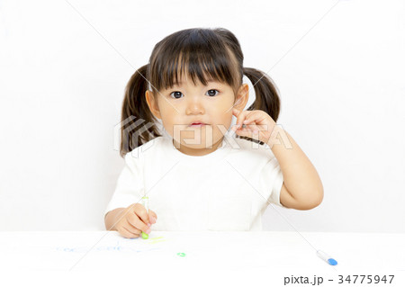 クレヨンで絵を描いて遊ぶ幼い女の子のカメラ目線 クレヨンで絵を描いて遊ぶ幼い女の子のカメラ目線 34775947