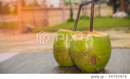 coconut juice and brown tube on wooden table coconut juice and brown tube on wooden table 34793978