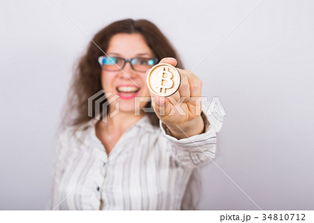 Business woman holding a Golden Bitcoin. Virtual 34810712