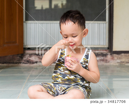 Thai boy eating cup cake by spoon Thai boy eating cup cake by spoon 34817706