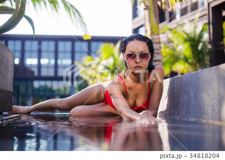 beautiful female model posing by the pool. toned 34818204