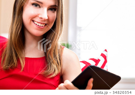 Young woman using her tablet at home Young woman using her tablet at home 34820354
