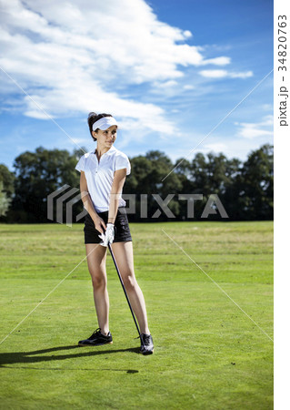 Pretty girl playing golf on grass 34820763