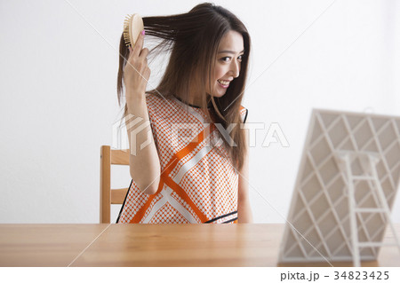 部屋で髪をブラッシングする女性 部屋で髪をブラッシングする女性 34823425