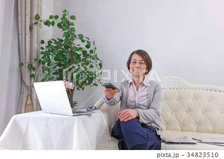 ミドル女性 キャリアウーマン 情報収集 TVリモコン ミドル女性 キャリアウーマン 情報収集 TVリモコン 34823510