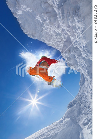 Snowboarder jumping against blue sky Snowboarder jumping against blue sky 34825275