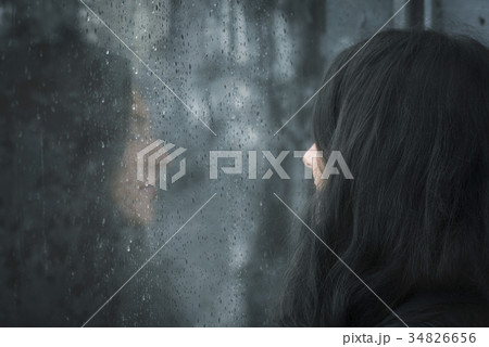 Woman in front of rainy window 34826656
