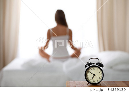Alarm clock standing on bedside table has already 34829129