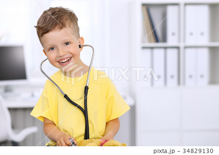 Little doctor examining a 
toy bear  patient b 34829130