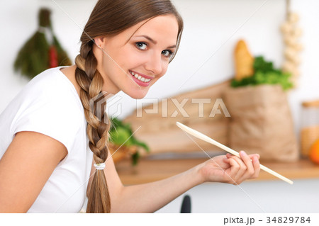 Young woman is cooking in a kitchen. Housewife is 34829784