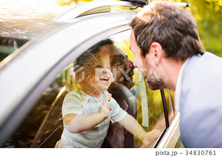 Little boy in the car looking at his father. 34830761
