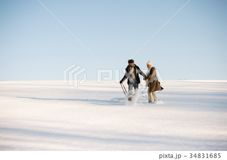 Beautiful senior couple on a walk pulling sledge 34831685