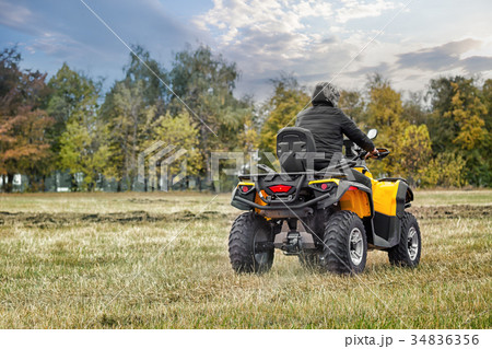 Racer on yellow ATV leaving into the distance Racer on yellow ATV leaving into the distance 34836356