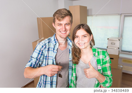 Happy funny couple showing keys of new home Happy funny couple showing keys of new home 34838489
