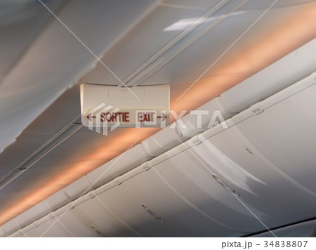 emergency exit sign on the ceiling of airplane emergency exit sign on the ceiling of airplane 34838807