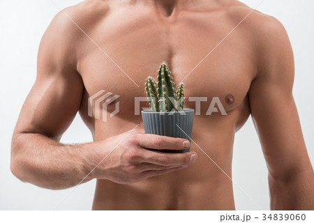 Youthful guy is showing prickly houseplant 34839060