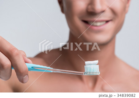 Happy guy is standing with dental tool Happy guy is standing with dental tool 34839082