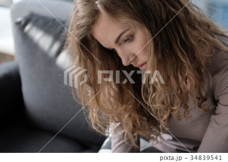 Depressed female sitting on cozy sofa 34839541
