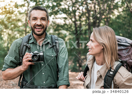 Cheerful married couple photographing forest 34840126