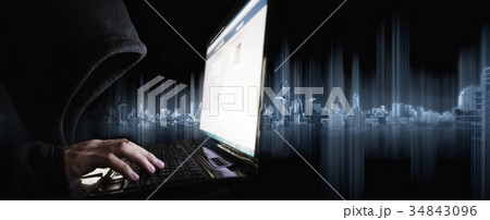 Hacker in Black Hood using Laptop Computer Hacker in Black Hood using Laptop Computer 34843096